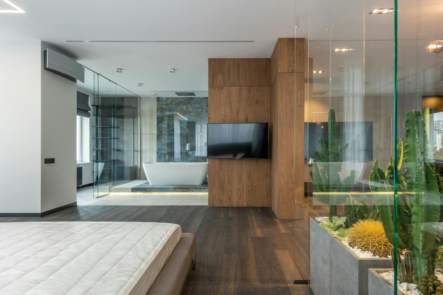 Nowoczesna sypialnia połączona z łazienką za szklaną ścianą