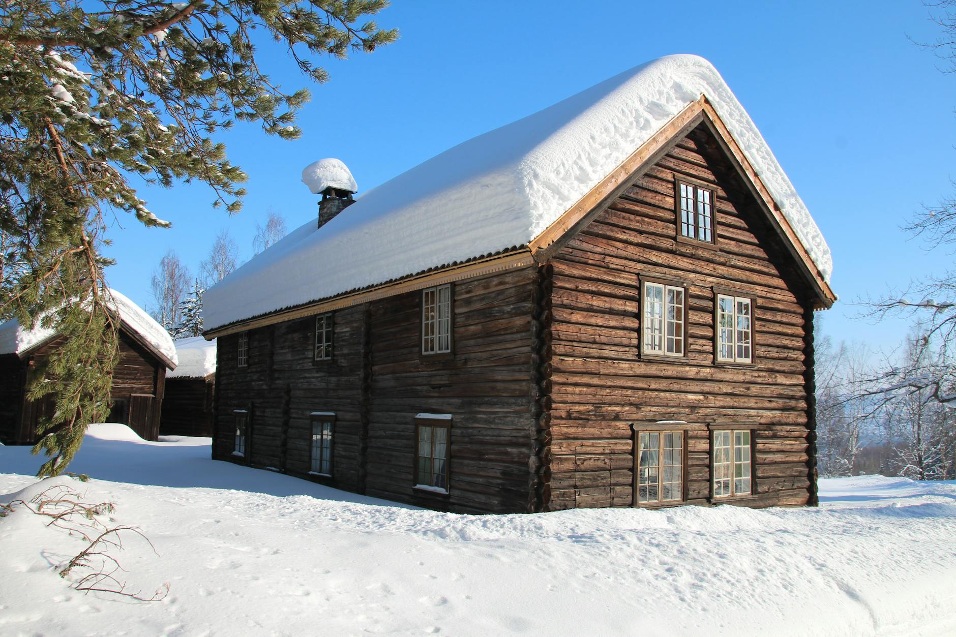 Ocieplenie dawnych domów: mchy, glina, trociny i ich skuteczność w praktyce Drewniana chata wśród śniegu, zimowy krajobraz dawniczego budownictwa