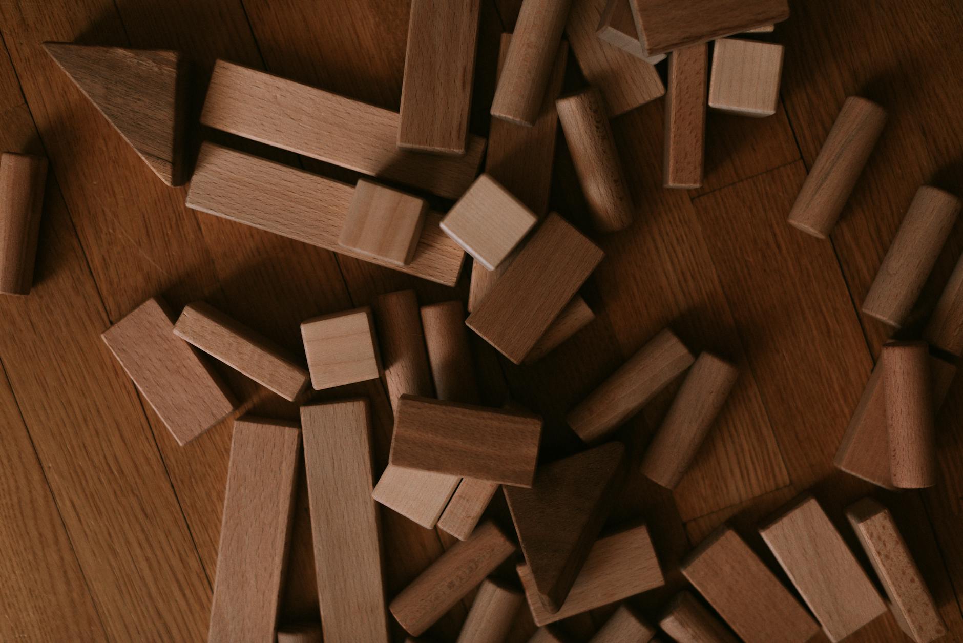 Drewniane klocki rozłożone na podłodze oglądane z góry
