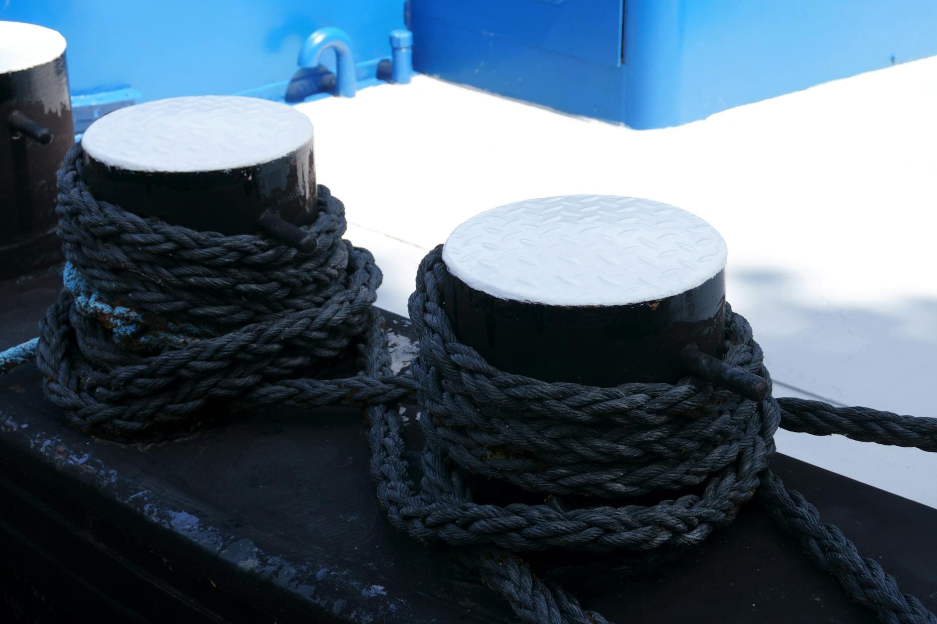 Liny owinięte wokół stalowych polerów na pokładzie statku