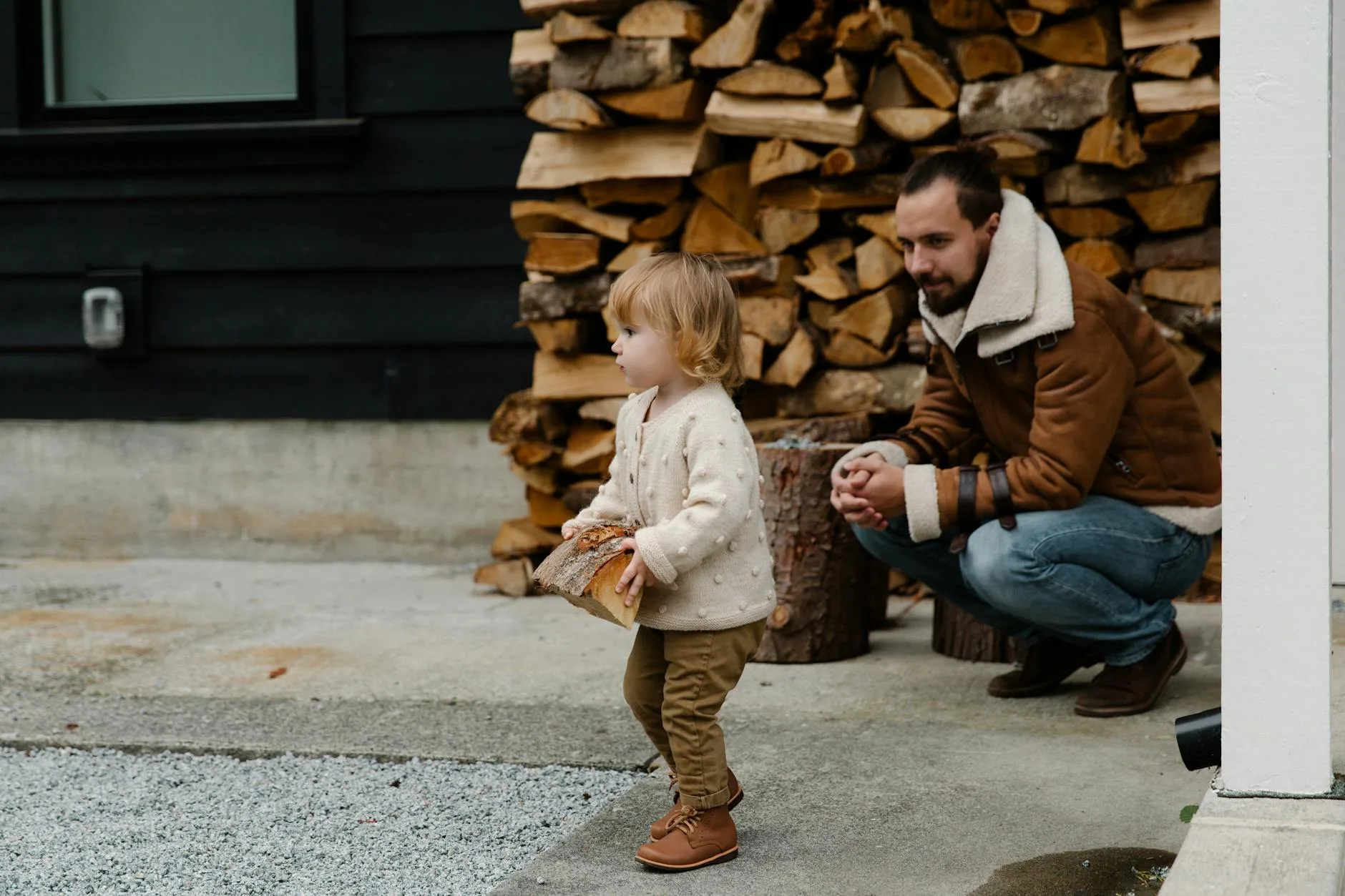 Mężczyzna i dziecko bawią się drewnem opałowym na podwórku