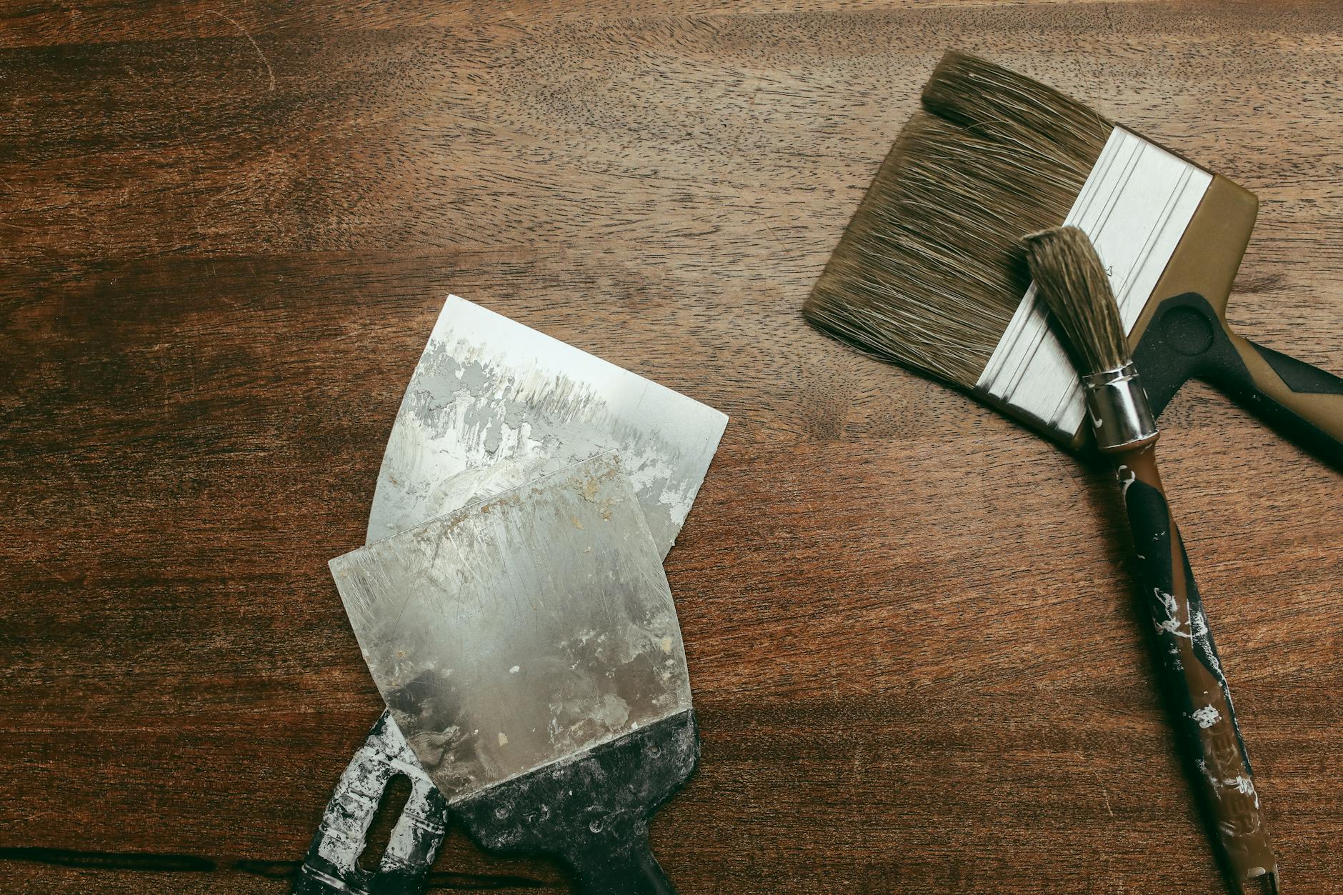 Pędzle i szpachelki rozłożone na drewnianej desce