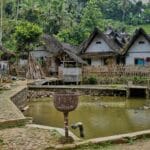 Tradycyjne indonezyjskie domy z liściastymi dachami nad stawem