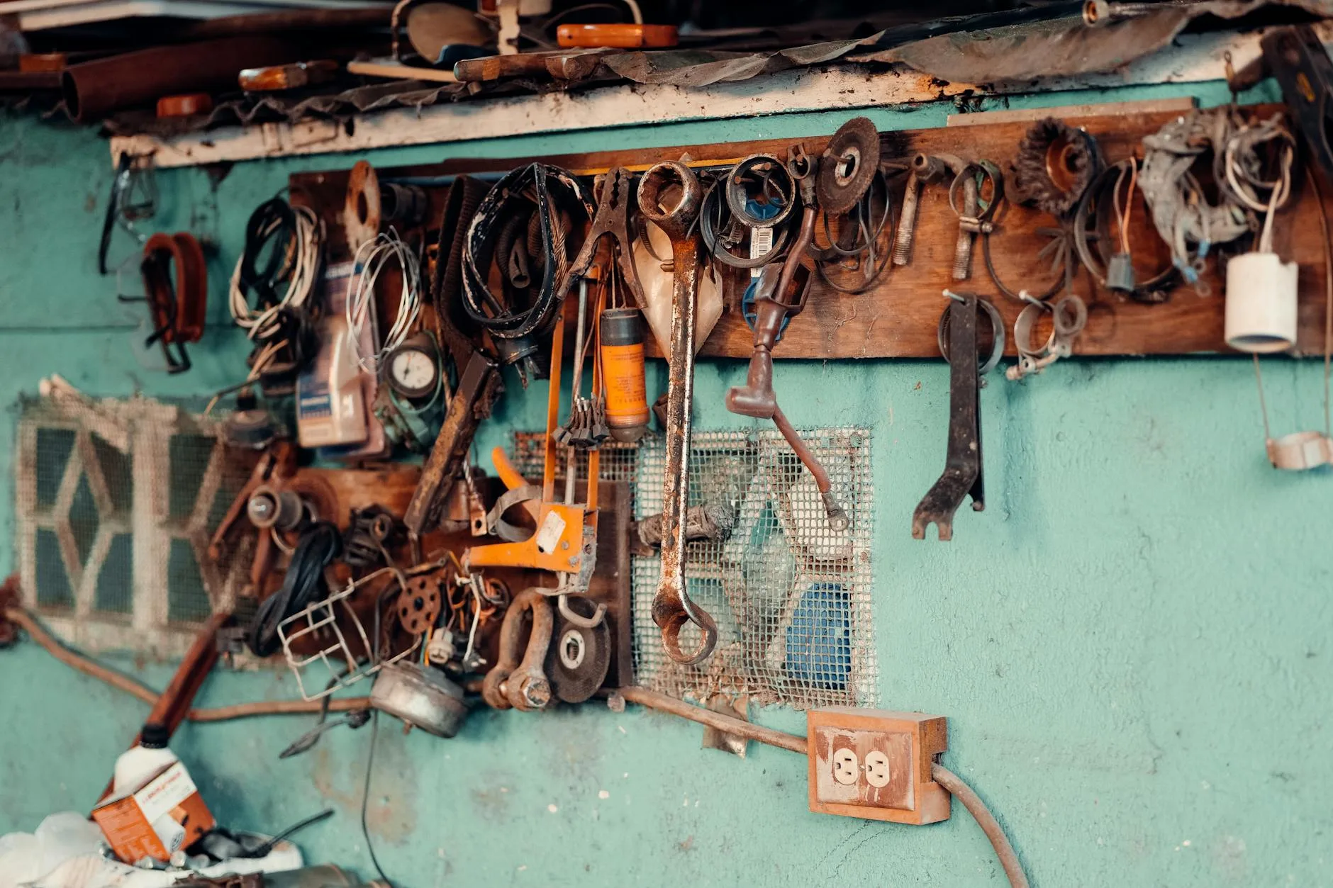 Zabytkowe narzędzia stolarskie wiszące na ścianie drewnianego warsztatu