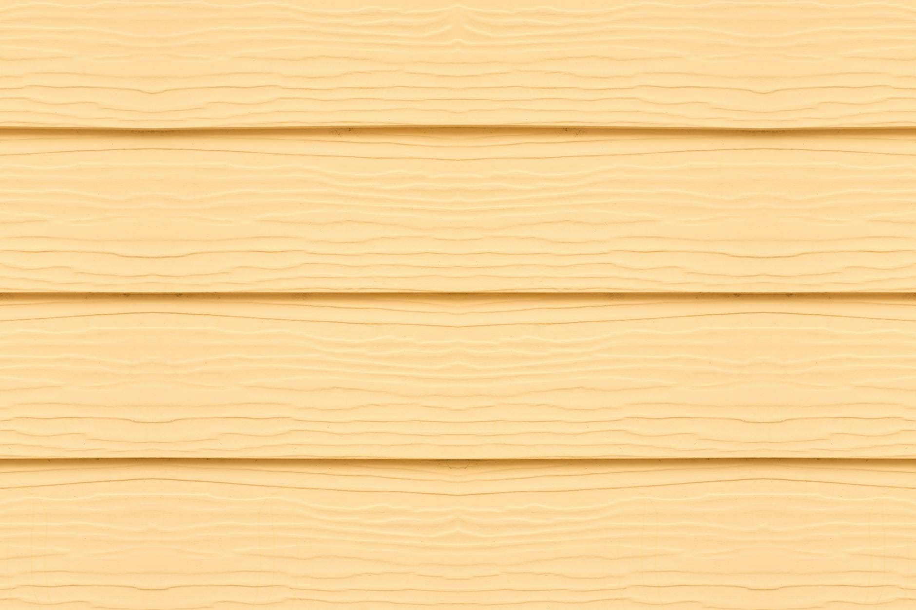 Żółte drewniane deski elewacyjne z wyraźną fakturą w zbliżeniu