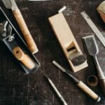 Struganie a szlifowanie: kiedy wystarczy strug, a kiedy potrzebujesz papieru Zestaw narzędzi stolarskich na stole warsztatowym do obróbki drewna