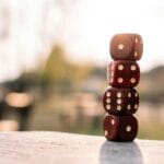 Kiedy deska tarasowa pęcznieje po deszczu i co z tym zrobić Czerwone kości do gry na drewnianym stole na nasłonecznionym tarasie