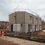 Nowoczesny dom szkieletowy w budowie z rusztowaniem i ogrodzeniem