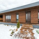 Nowoczesny drewniany dom pasywny zimą z zasobem drewna opałowego