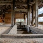 Od bali do prefabrykacji: historia przyspieszenia budowy w drewnie Tradycyjny drewniany tartak w Norwegii ukazujący rzemiosło ciesielskie