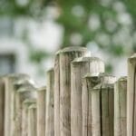 Zbliżenie na poziome drewniane ogrodzenie na tle rozmytej zieleni