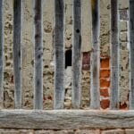 Zbliżenie ściany z drewnianymi belkami i odsłoniętą cegłą