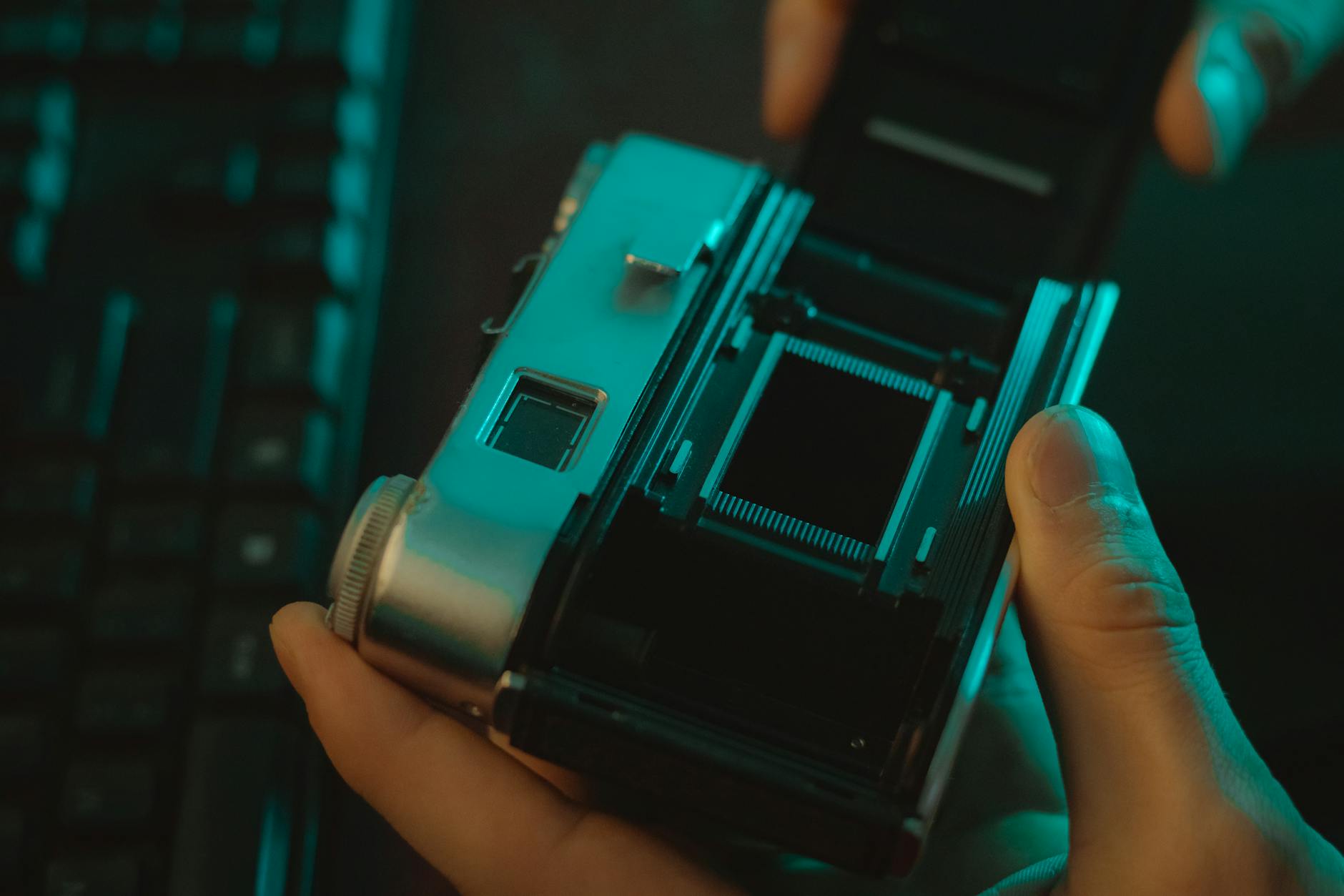 Jak sprawdzić szczelność okien drewnianych świeczką i kamerą termowizyjną Mężczyzna sprawdza tył starego aparatu fotograficznego