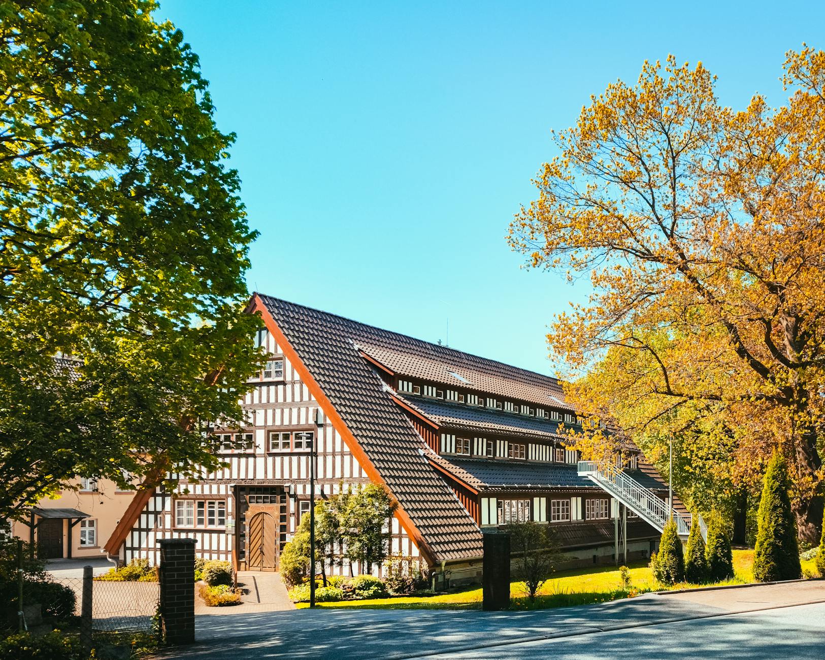 Półdrewniany dom w jesiennej scenerii na tle błękitnego nieba