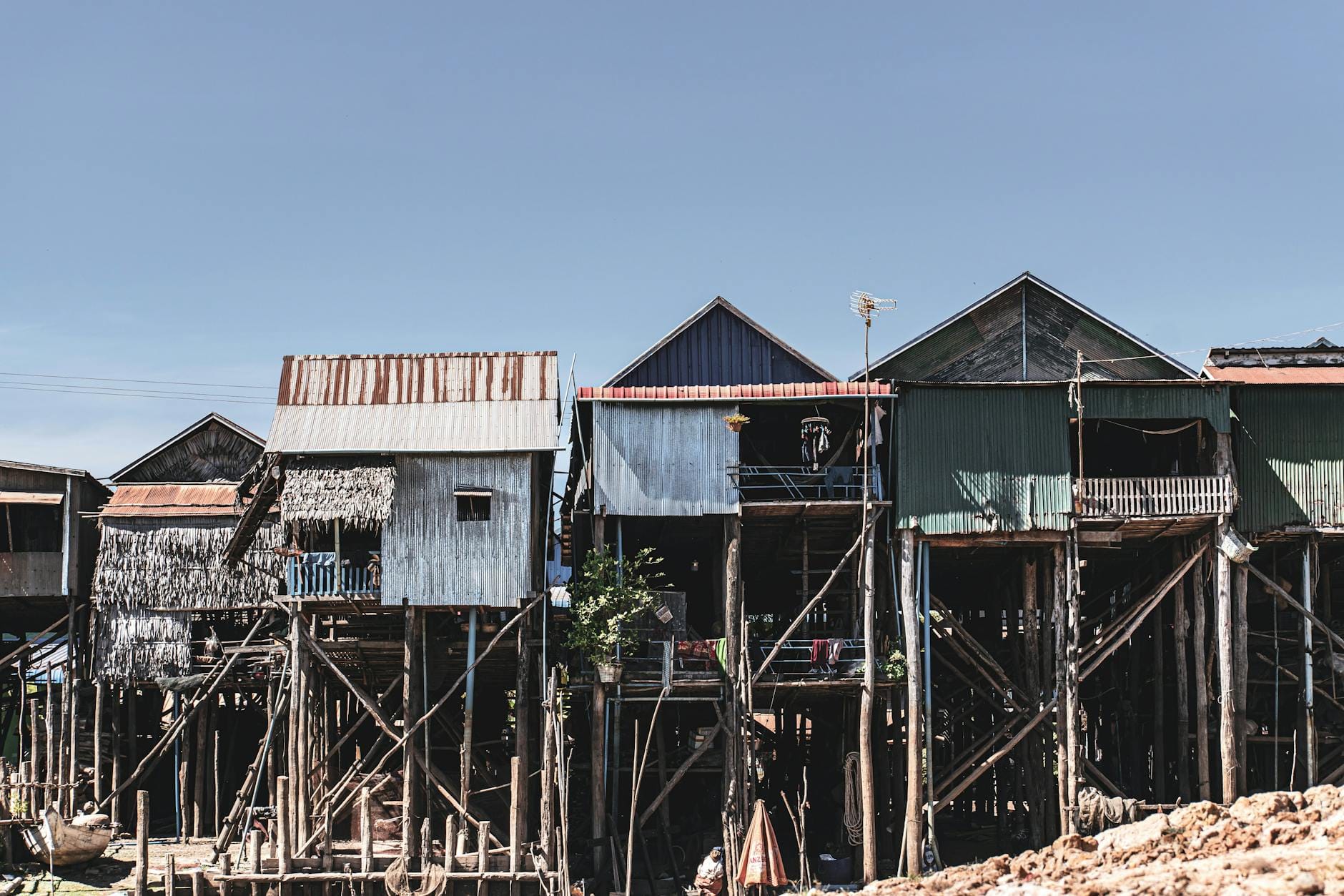 Tradycyjne domy na drewnianych palach w Kampong Phluk na tle błękitnego nieba