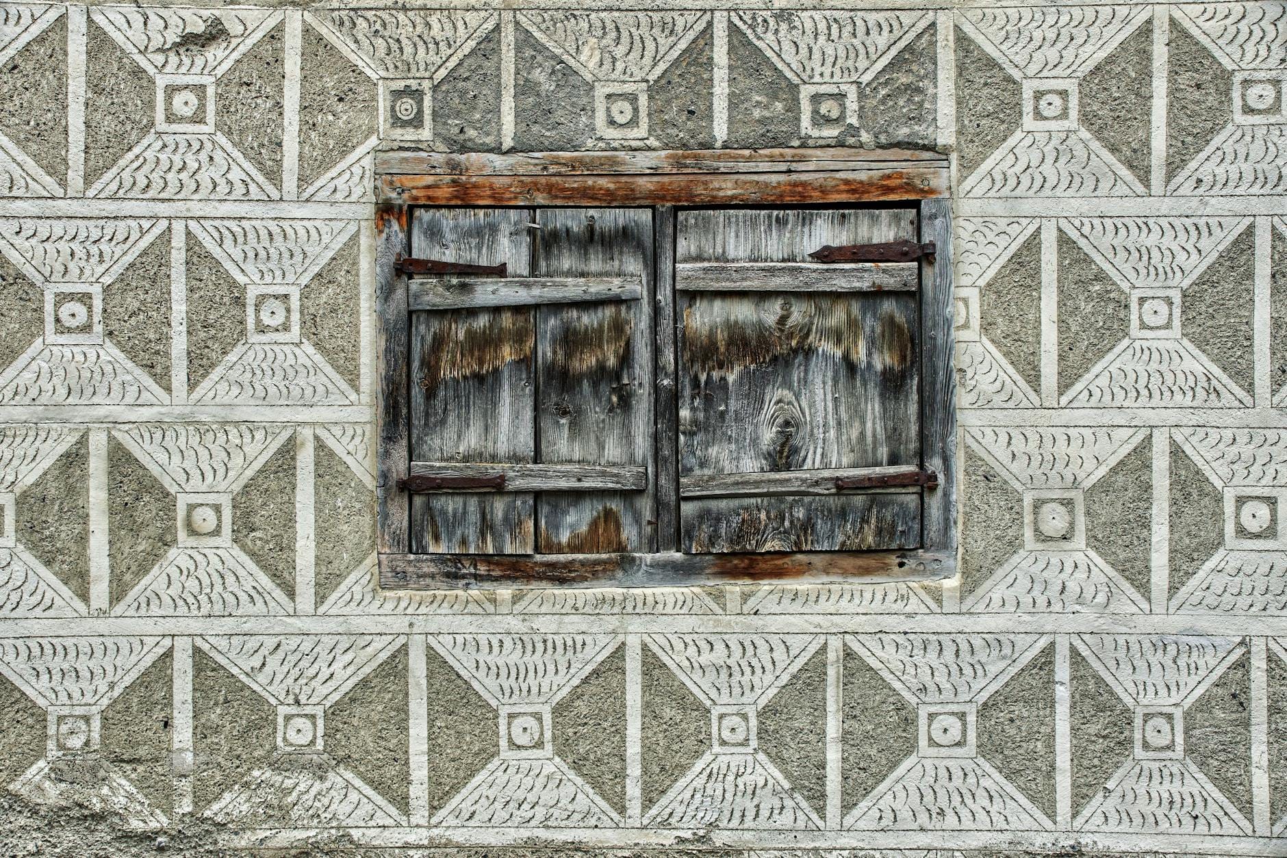 Zbliżenie starej drewnianej okiennicy na geometrycznej elewacji