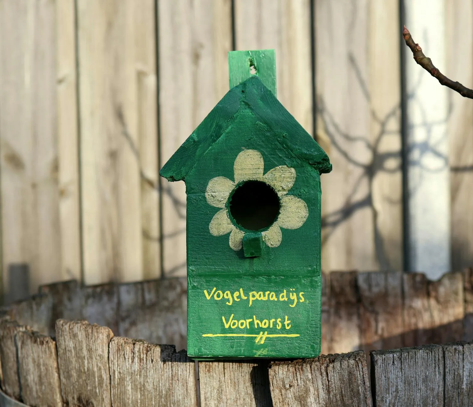 Jak zrobić budkę lęgową dla sikorek z właściwym otworem wlotowym i odpornym dachem Zielona drewniana budka lęgowa z motywem kwiatów w ogrodzie